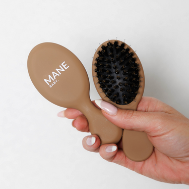 The Mane Baby Mini Boar Bristle Brush is the ultimate hair brush for maintaining both your luxury hair extensions and natural hair whilst on the go . Designed with a premium blend of boar bristles and nylon bristles, this brush effortlessly detangles while nourishing your hair by distributing natural oils from root to tip, leaving your locks silky and smooth.